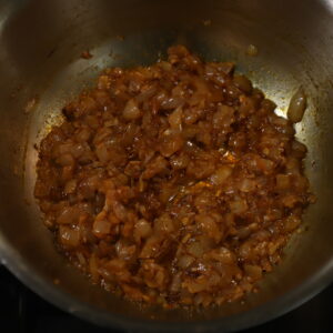 Diced onion and spices browned in a pot.