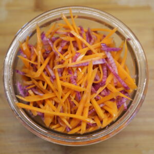 Glass bowl filled with purple and orange matchsticks.