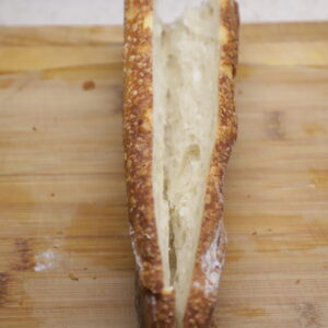 Sourdough baguette cut lengthwise, except for the tip.