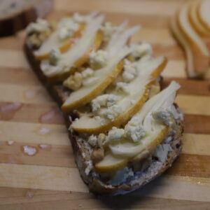 Pear and fennel on sourdough slice with walnut and blue cheese pieces.